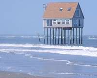 Barrier-island migration drives large-scale marsh loss