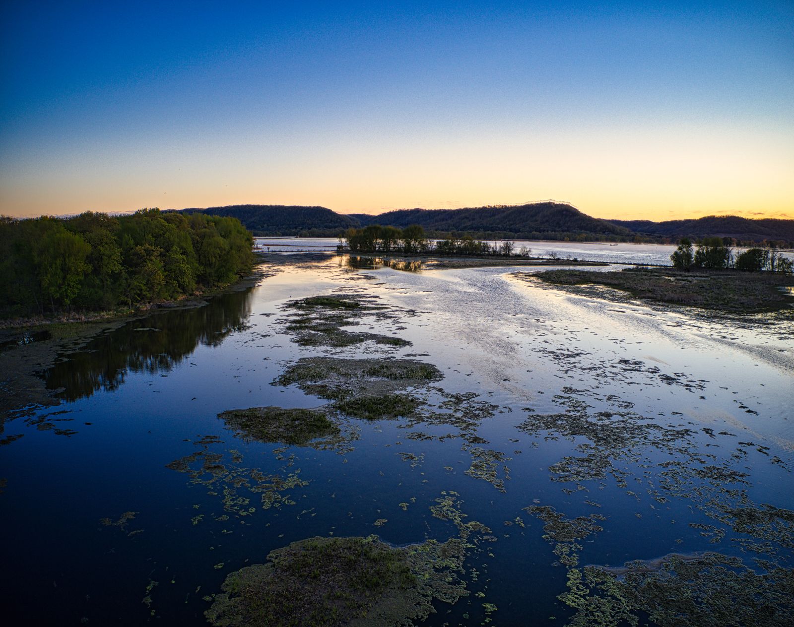 What happened when a Midwestern industrial river that once caught fire in 1969 was dredged, re-oxygenated and lined with restored wetlands, and dozens of fish species returned to a channel biologists had written off as biologically dead?
